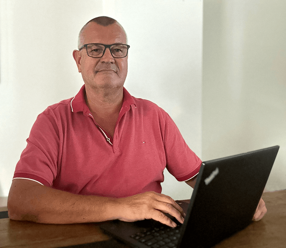 A man working on a laptop, likely using membership management software for a sports club